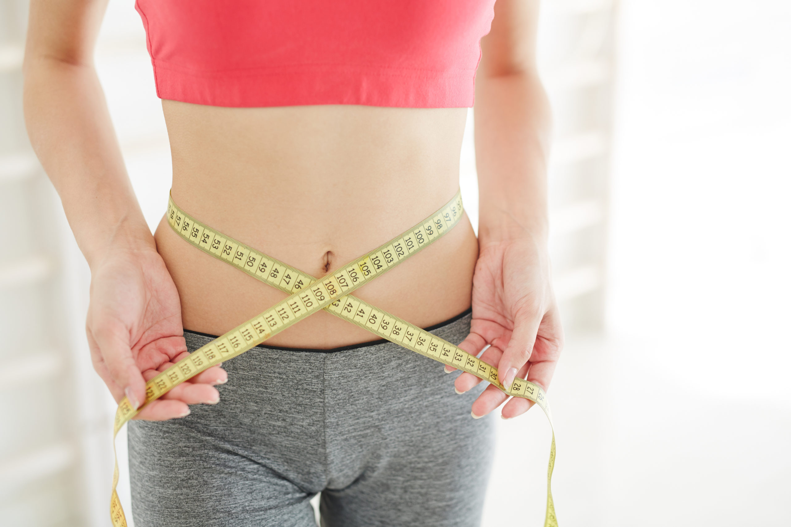 Young female measuring her weight Loss | Pure Hydration and Aesthetics in Cedar City, UT